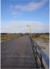 Von der Promenade hinter den Dnen fhrt die 1.095 m lange Seebrcke ber die Salzwiesen bis zum Strand mit den Pfahlbauten.